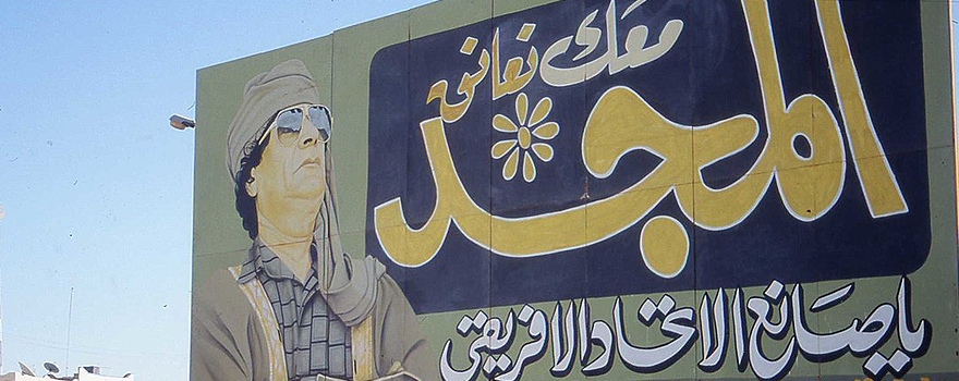Propaganda poster extolling Gaddafi, near Ghadames, 2004 [Sludge G., Wikipedia].