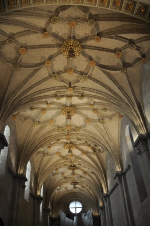 Star-shaped ribbed vaults of the abbey church, from the mid-16th century, with the coat of arms of Archbishop Hernando de Aragón. 