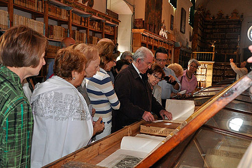 Don Julio Gorricho showing some of the printed copies preserved in the Library Services Capitular of the Cathedral of Pamplona to the attendees of visit