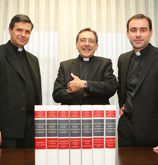 Antonio Viana, Javier Otaduy and Joaquín Sedano pose next to the Diccionario General de Derecho Canónico.